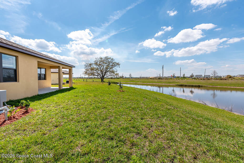 1863 Farmhouse Road Southeast Palm Bay, FL 32909 - Photo 10 of 44 a view of a house with a yard and a large tree