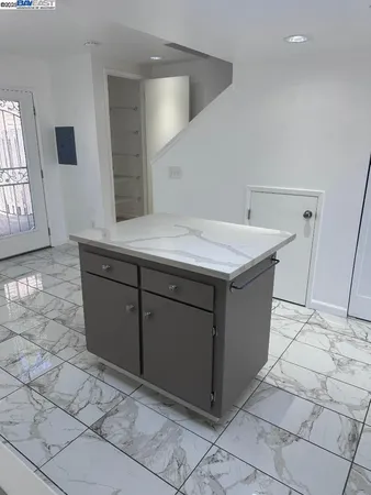 a kitchen with stainless steel appliances kitchen island granite countertop a refrigerator and a sink