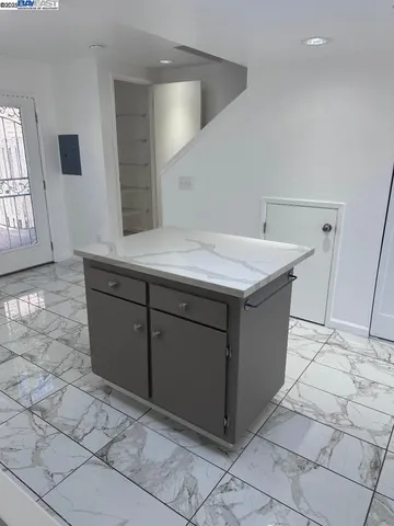 a kitchen with stainless steel appliances kitchen island granite countertop a refrigerator and a sink