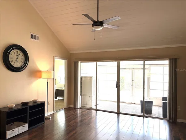 a view of a livingroom with furniture wooden floor and a ceiling fan