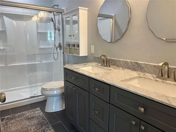 a bathroom with a granite countertop sink toilet and a mirror