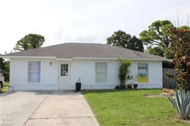 a front view of house with yard and trees around