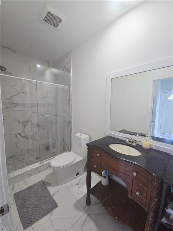 5321 Warren Street Naples, FL 34113 - Photo 19 of 21 a bathroom with a granite countertop sink a toilet and shower