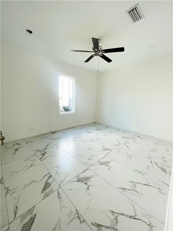 5321 Warren Street Naples, FL 34113 - Photo 20 of 26 en empty room with wooden floor and windows