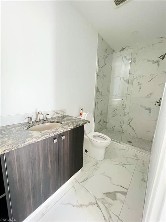 5321 Warren Street Naples, FL 34113 - Photo 24 of 26 a bathroom with a granite countertop sink toilet and shower