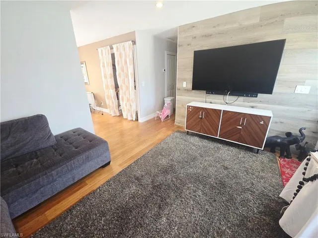 a large kitchen with stainless steel appliances granite countertop a refrigerator a sink dishwasher a stove and white countertops with wooden floor