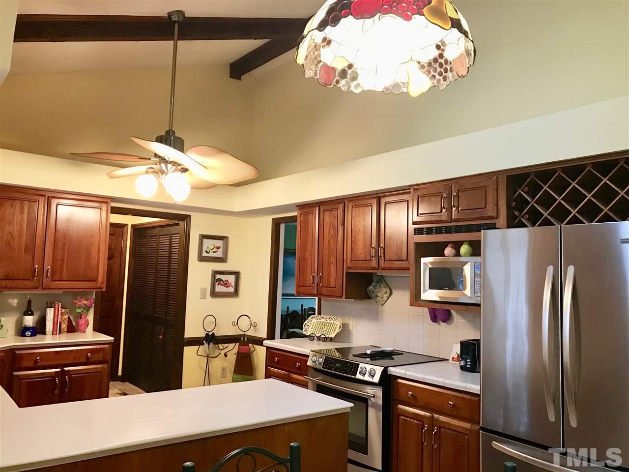 1115 Hunting Ridge Road Raleigh, NC 27615 - Photo 3 of 25 a kitchen with stainless steel appliances a stove refrigerator and cabinets