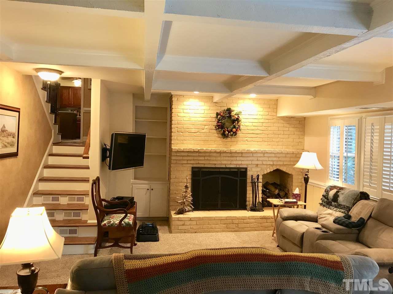 1115 Hunting Ridge Road Raleigh, NC 27615 - Photo 10 of 25 a living room with furniture a fireplace and a flat screen tv