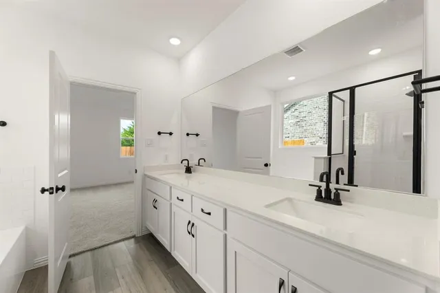 a bathroom with a double vanity sink and mirror