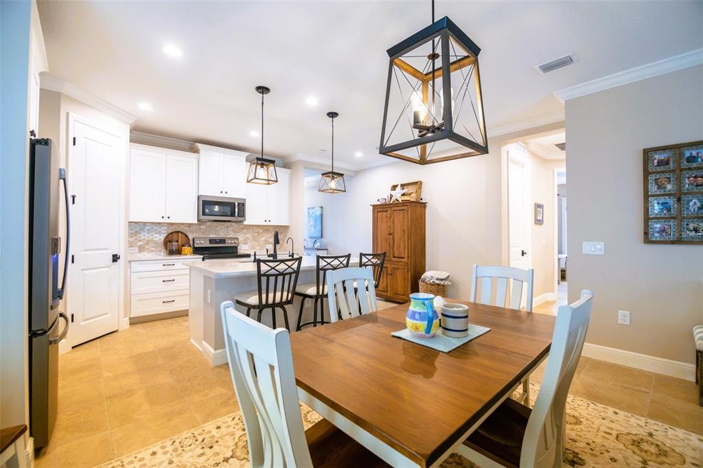 13153 Steinhatchee Loop Venice, FL 34293 - Photo 11 of 33 a open kitchen with stainless steel appliances a dining table chairs stove and refrigerator