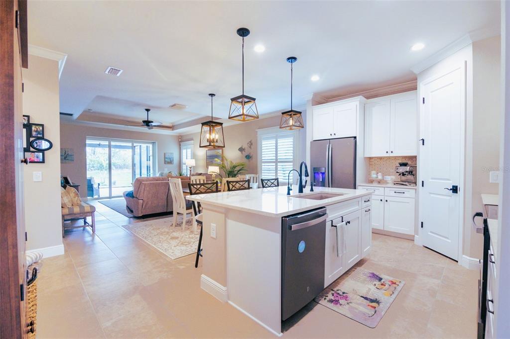 13153 Steinhatchee Loop Venice, FL 34293 - Photo 10 of 33 a kitchen with kitchen island cabinets a sink a center island and a window