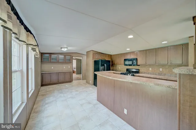 a view of kitchen with refrigerator cabinets and a sink