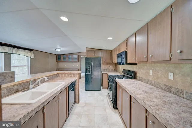 a kitchen with a sink stove top oven and refrigerator