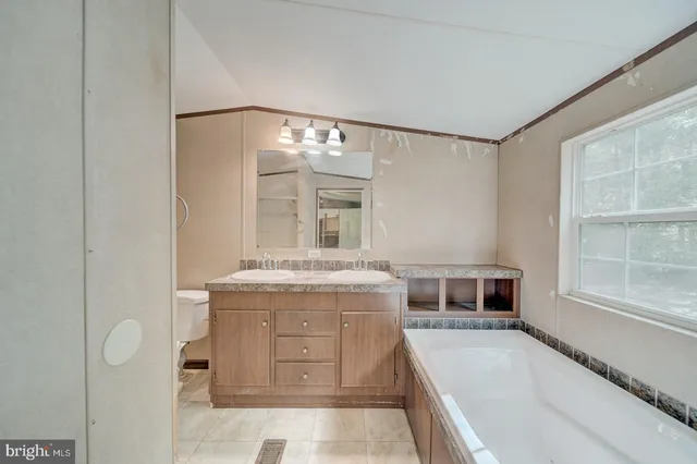 a spacious bathroom with a granite countertop tub sink and mirror