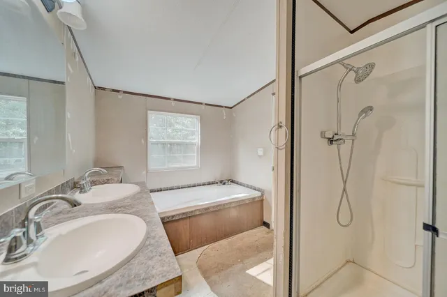 a bathroom with a granite countertop sink a mirror and shower