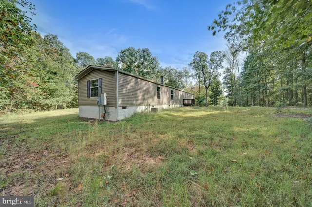 a view of backyard of house with green space