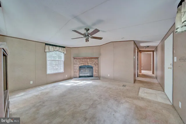 an empty room with windows and ceiling fan