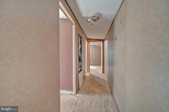 a view of a hallway with wooden floor and entryway