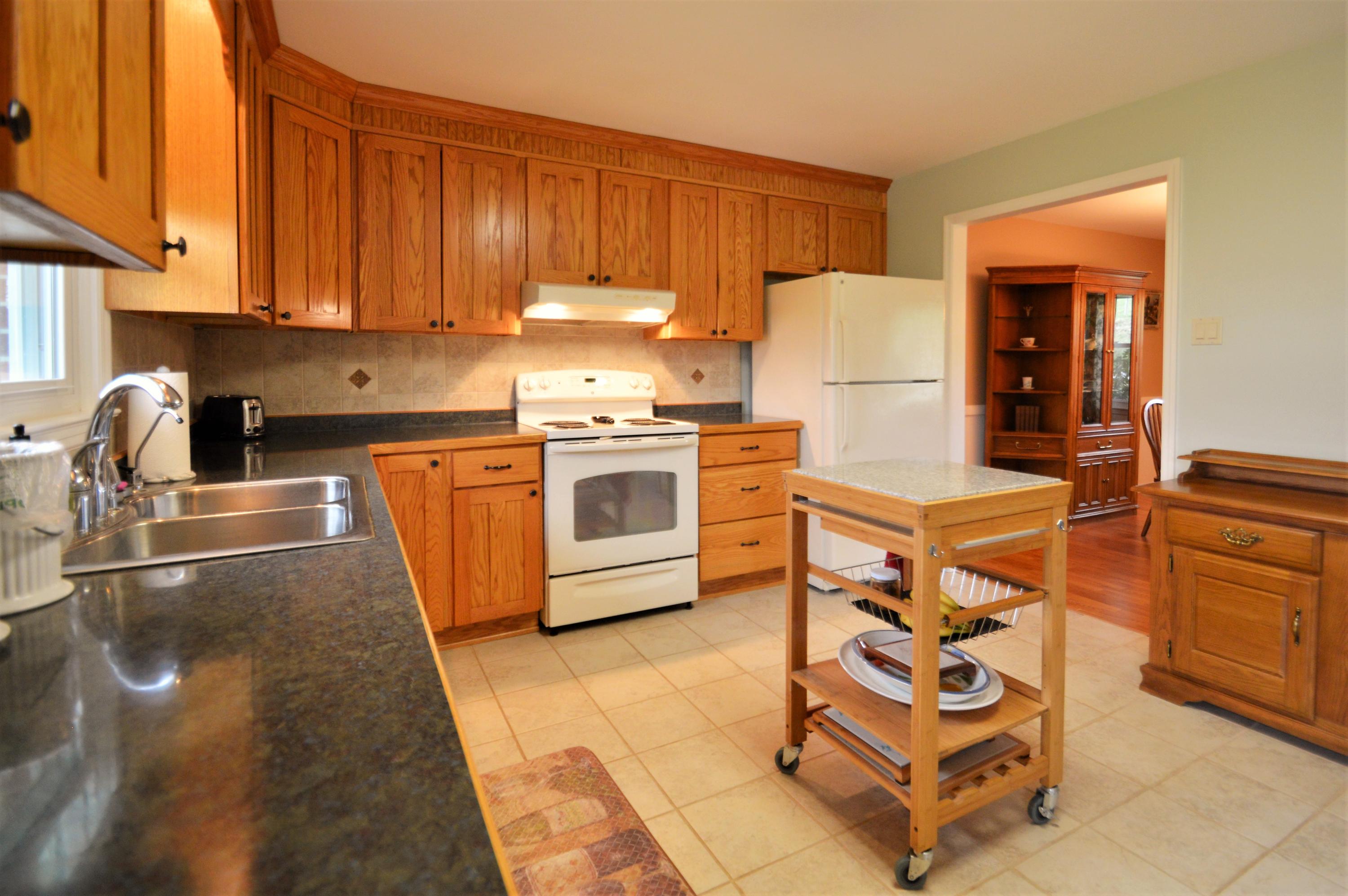 426 Poor Farm Road Southeast Floyd, VA 24091 - Photo 8 of 40 a kitchen with stainless steel appliances granite countertop a stove top oven a sink a refrigerator and white cabinets with wooden floor