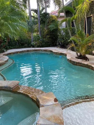 a view of a lake with a yard and large trees