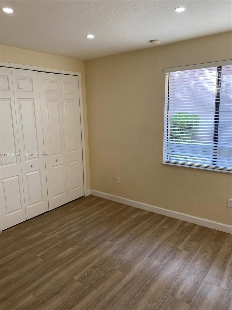 7564 Southwest 190th Street, Unit 7564 Cutler Bay, FL 33157 - Photo 16 of 22 a view of an empty room with wooden floor and a window