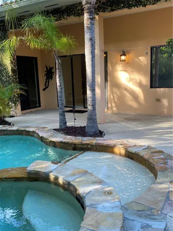 a view of a house with backyard sitting area and swimming pool