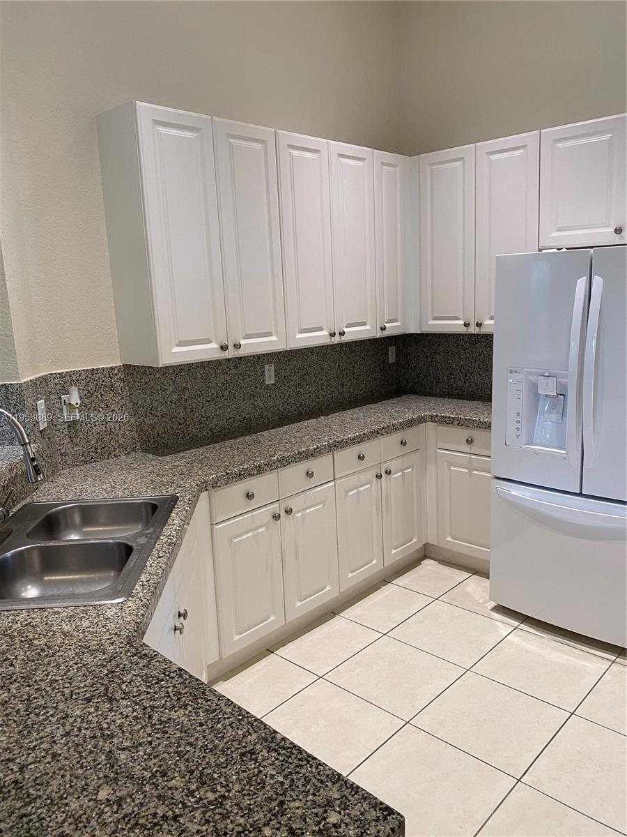 7564 Southwest 190th Street, Unit 7564 Cutler Bay, FL 33157 - Photo 7 of 22 a kitchen with granite countertop a sink and a stove