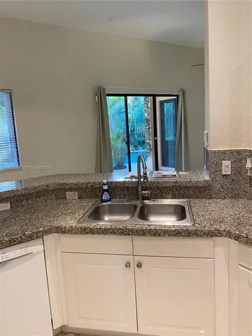 a kitchen with granite countertop a sink and a window
