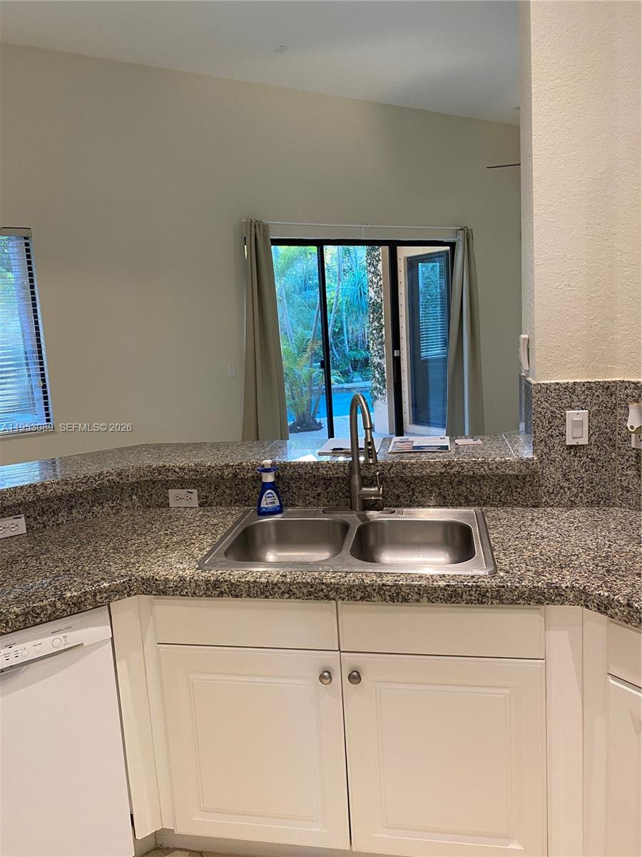 7564 Southwest 190th Street, Unit 7564 Cutler Bay, FL 33157 - Photo 9 of 22 a kitchen with granite countertop a sink and a window