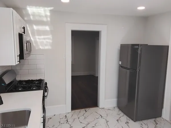 a kitchen with a refrigerator and a stove top oven