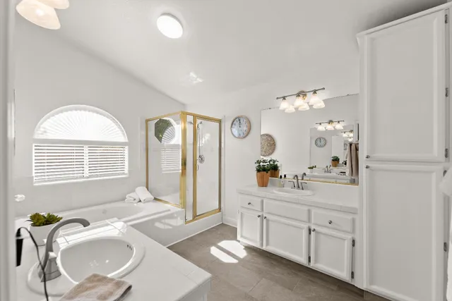 a en suite bathroom with double vanity a bathtub a mirror and a shower