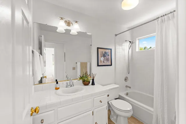 a bathroom with a sink a toilet a large mirror and shower