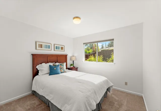 a bedroom with a bed and painting on the wall