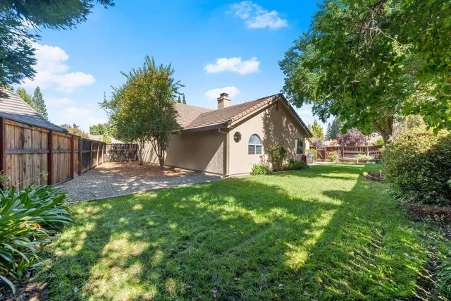a view of a house with backyard and sitting area