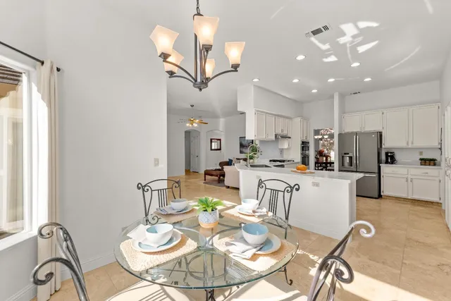 a open kitchen with stainless steel appliances kitchen island granite countertop a dining table and chairs with wooden floor