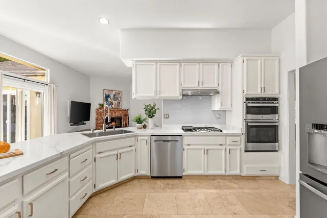 a kitchen with white cabinets and appliances