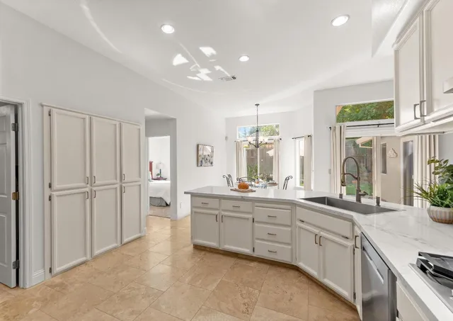 a large kitchen with a large window and stainless steel appliances