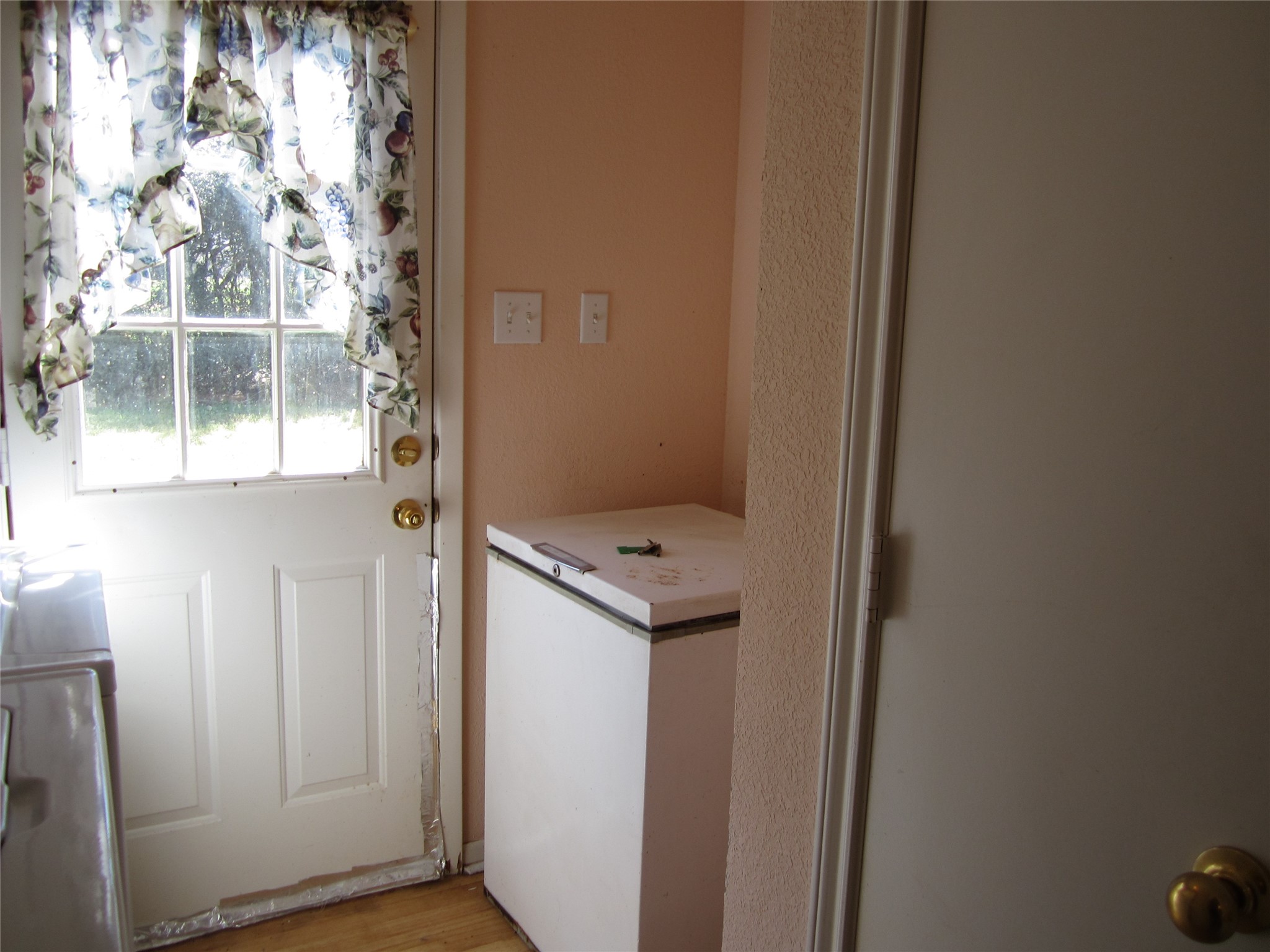 20697 Pierceall Road Hempstead, TX 77445 - Photo 11 of 35 This photo shows a small utility space with a side door leading to the outside. The area includes a chest freezer that will convey with the sale of the home.