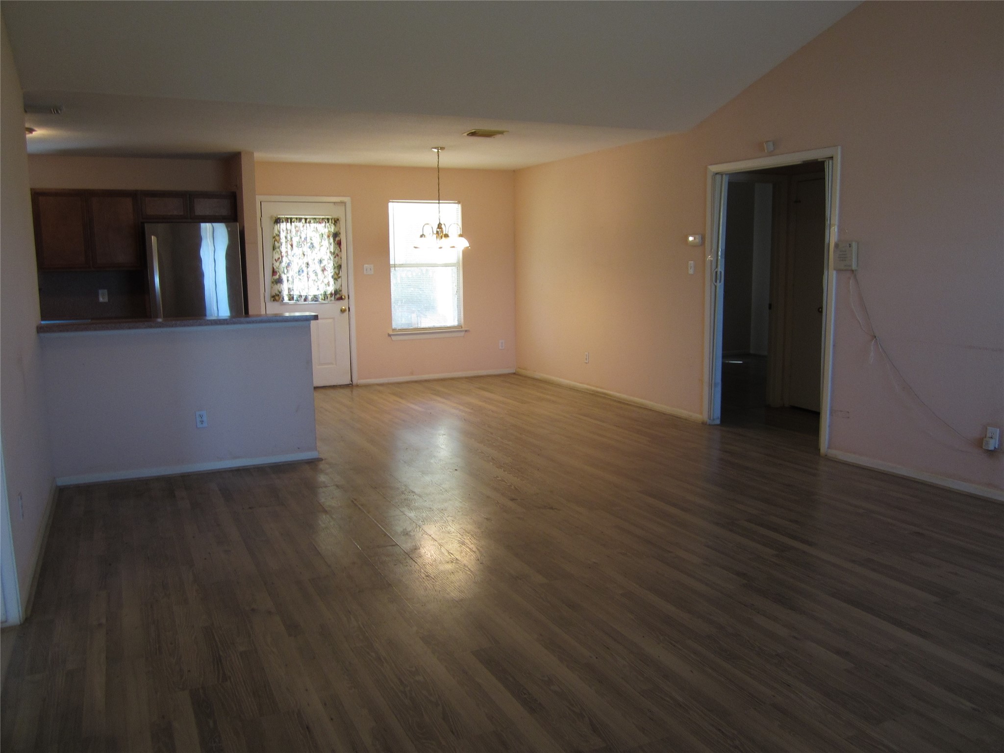 20697 Pierceall Road Hempstead, TX 77445 - Photo 15 of 35 This spacious living area features an open layout, and a view into the kitchen. A chandelier hangs above the dining area, and there's ample natural light from the window and door.