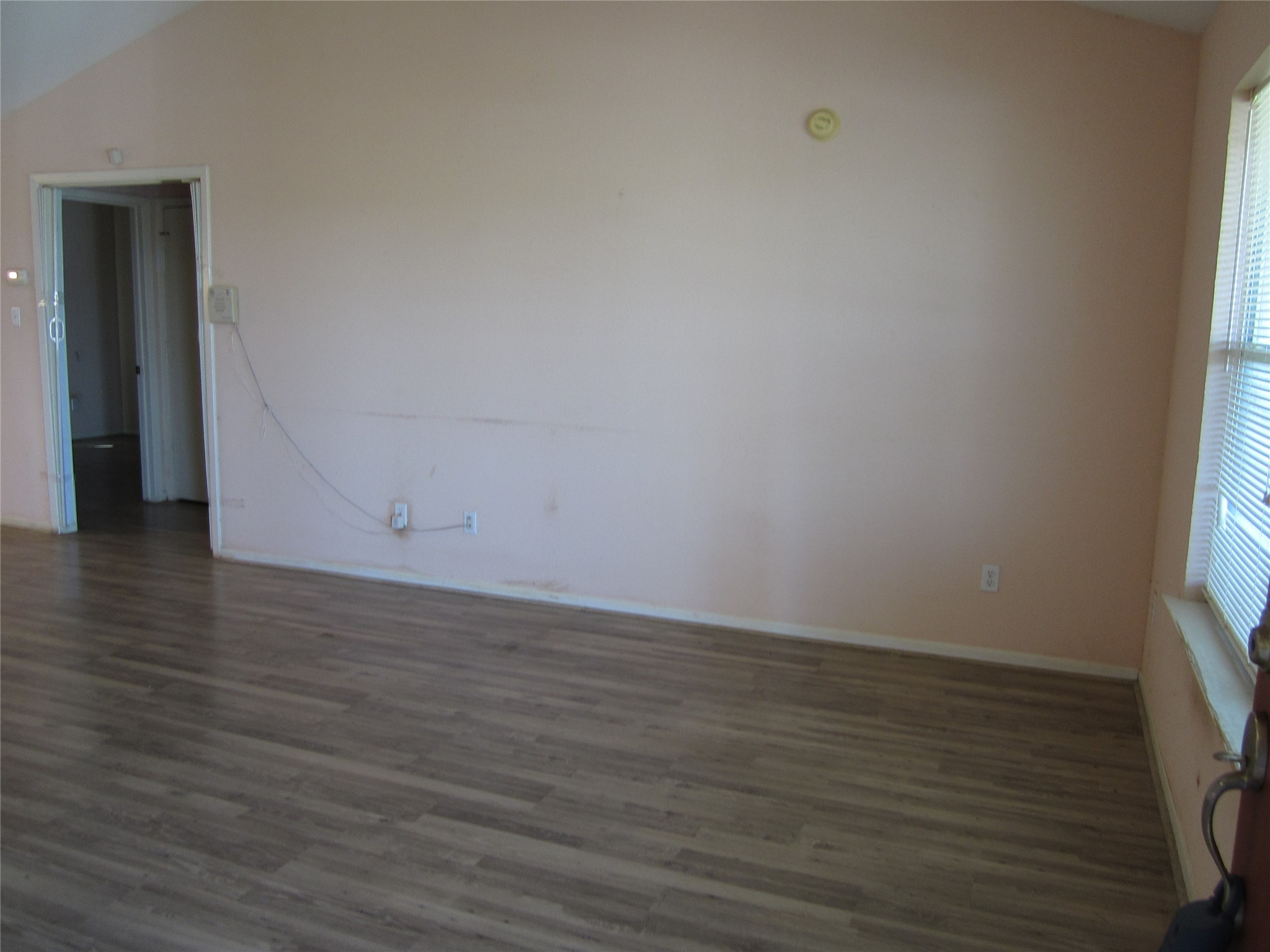 20697 Pierceall Road Hempstead, TX 77445 - Photo 16 of 35 The open concept living room features laminate flooring, with ample natural light from a large window. There's a doorway leading to secondary bedrooms and bathroom.