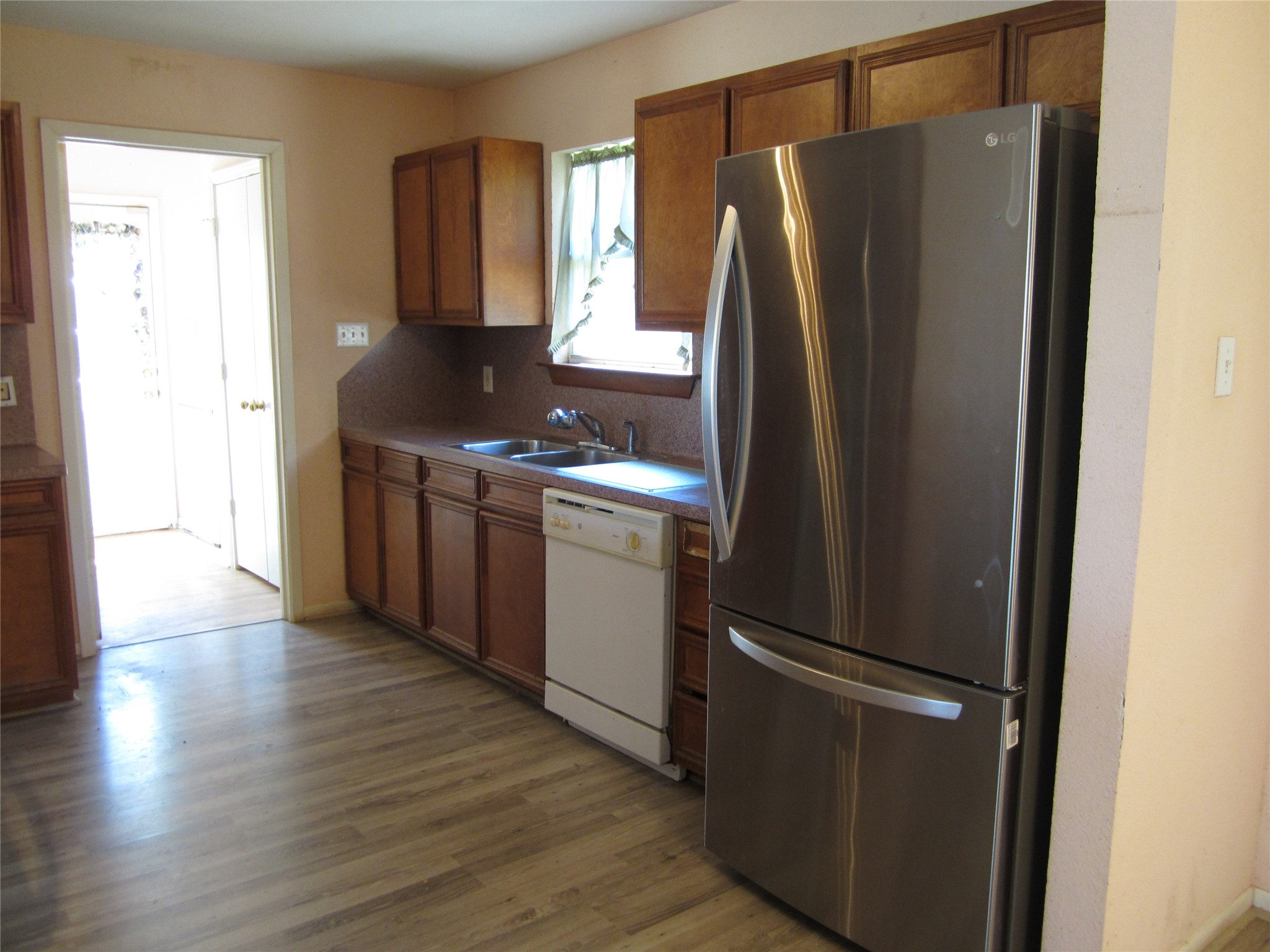 20697 Pierceall Road Hempstead, TX 77445 - Photo 5 of 35 It has a double sink under a window, and the space is accented by laminate wood flooring.