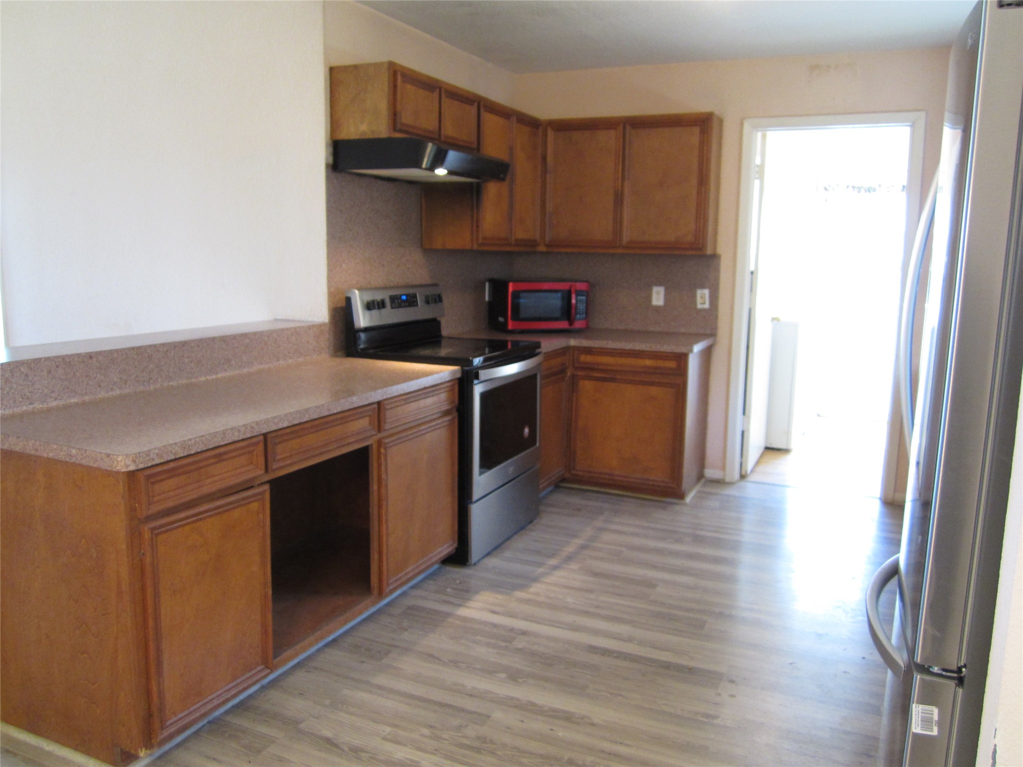 20697 Pierceall Road Hempstead, TX 77445 - Photo 8 of 35 This kitchen features a spacious countertop. It has a light wood floor and an open entryway to the utility room, washer, dryer and freezer convey with the sale.
