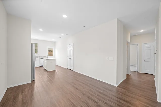 a view of a kitchen with wooden floor and a sink