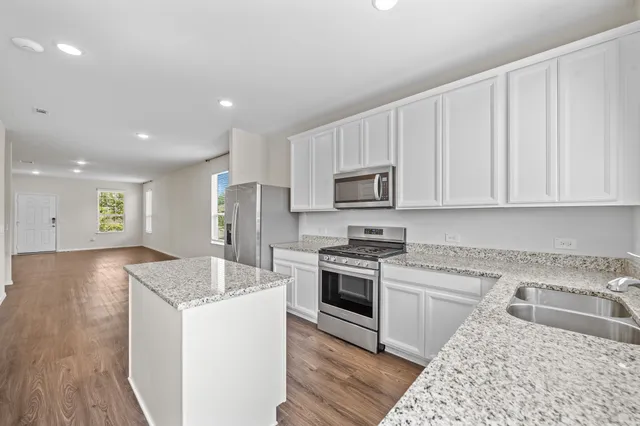 a kitchen with granite countertop white cabinets and white appliances