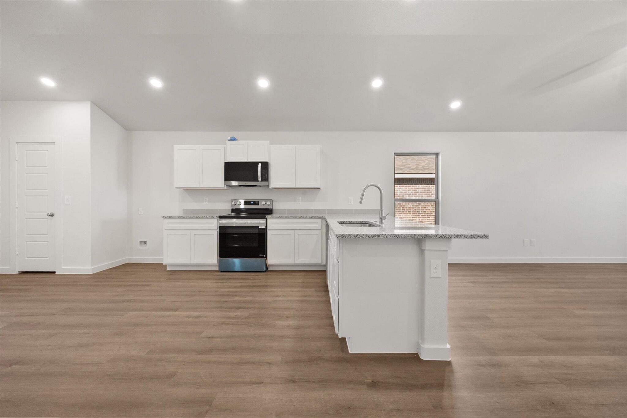 1317 North Chicago Avenue Lubbock, TX 79416 - Photo 9 of 20 a kitchen with granite countertop a stove top oven and cabinets