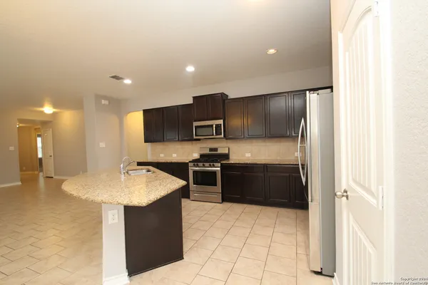 a large kitchen with kitchen island a sink stainless steel appliances and cabinets