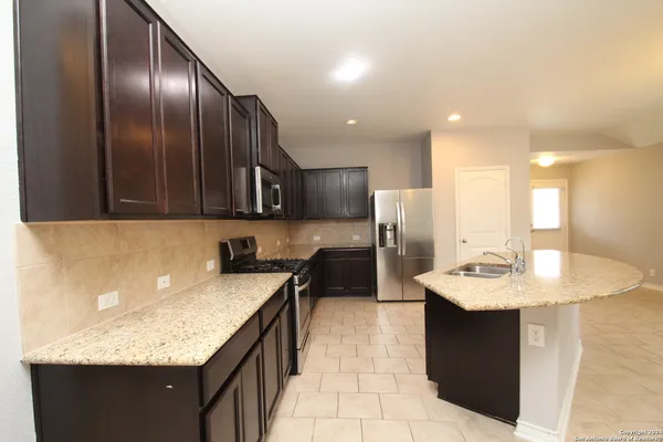 a kitchen with a sink refrigerator and microwave