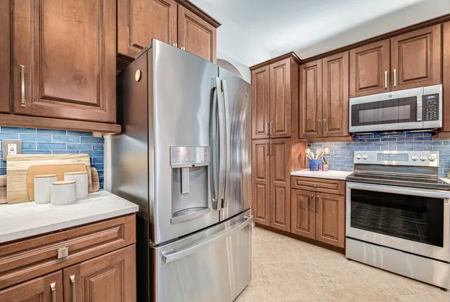 a kitchen with granite countertop a refrigerator stove and microwave