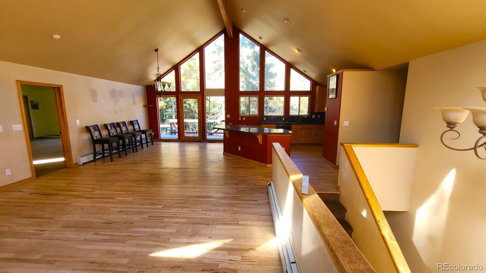 294 Red Tail Trail Evergreen, CO 80439 - Photo 2 of 35 a view of a living room and dining room with furniture wooden floor and windows