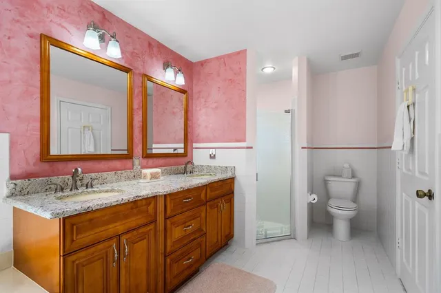 a bathroom with a granite countertop sink a toilet and a mirror